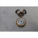 A small yellow metal top wound pocket watch stamped 18K having Roman numeral dial and perimeter 24hr