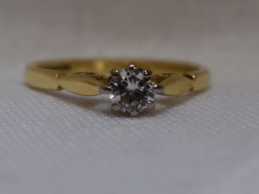 A lady's diamond solitaire dress ring, approx 0.25ct in a claw set raised mount to shaped