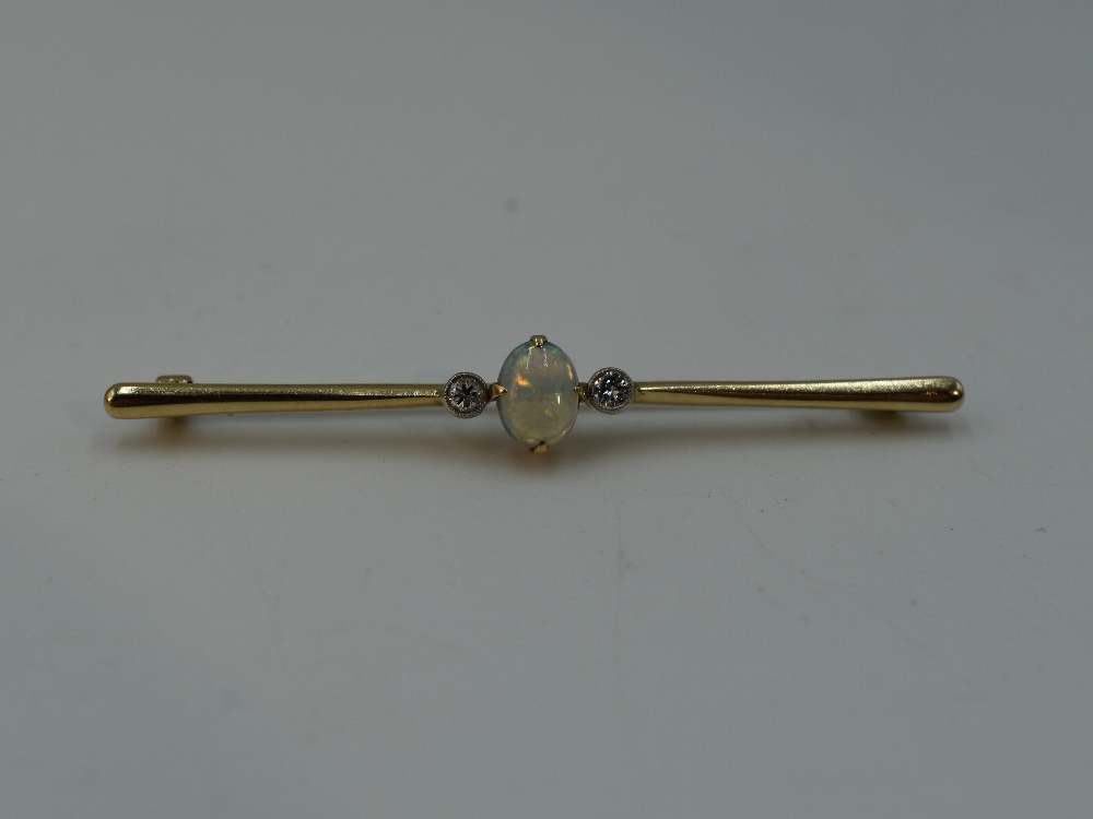 A 9ct gold bar brooch having a central opal flanked by two diamonds