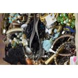 A basket of costume jewellery including bracelets, hair clips etc