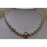 A string of south sea cultured pearls having a 18ct white gold and diamond Saturn clasp by Jorg