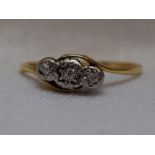 A lady's dress ring having a trilogy of diamond chips in an illusionary mount to cross over