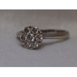 A lady's dress ring having a diamond daisy cluster, total approx 0.32ct to knife blade shoulders