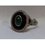 A lady's dress ring having a central emerald cabouchon in a black enamelled mount with diamond