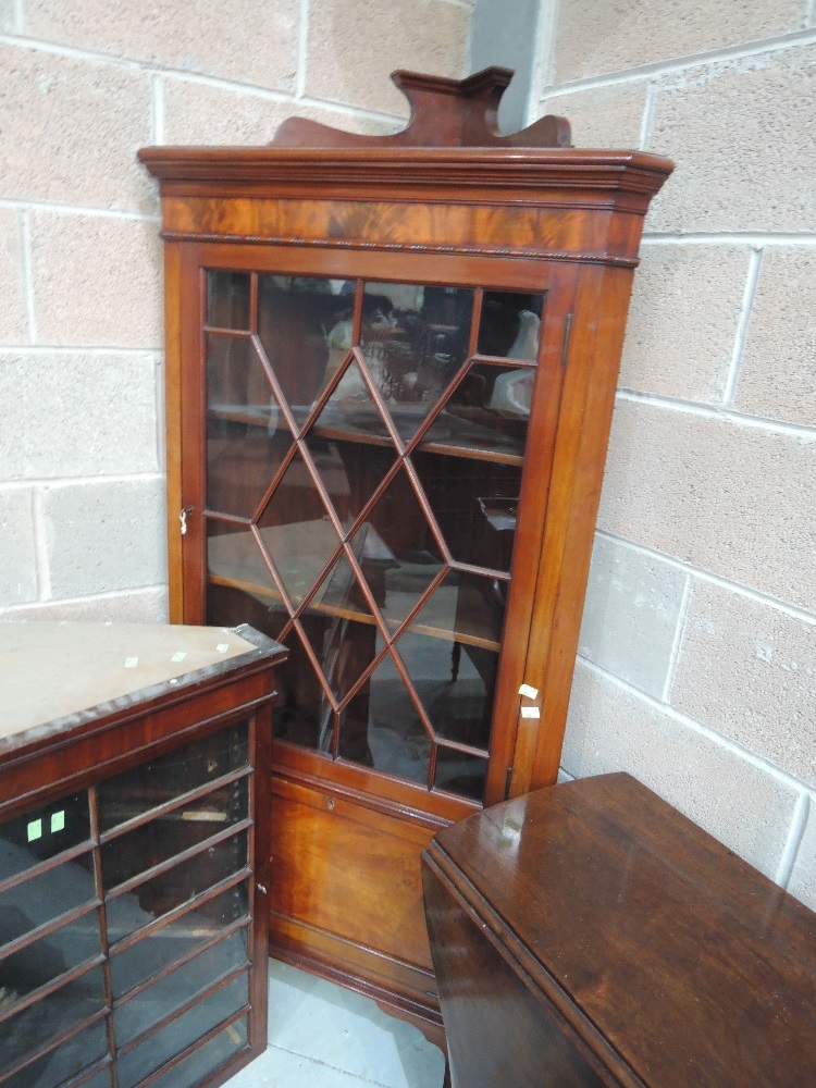 An Edwardian mahogany corner full height display cabinet having astral glazed top with cupboard base