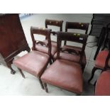 A set of four early/mid 19th Century mahogany dining chairs having carved, inlaid and scroll rail