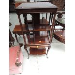 An Edwardian mahogany revolving bookstand having square spindle section top on cabriole and