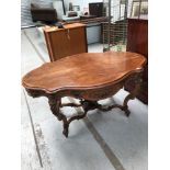 A Victorian walnut oval centre table having scroll frame and vase finial under, width approx. 142cm