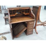An early 20th Century oak roll top desk having tambour shutter and single pedestal drawers,