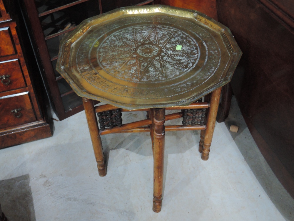 An early 20th century Eastern brass tray top occasional table on treen folding base, width approx.