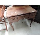 A 19th century mahogany low boy/side table having three frieze drawers with shaped apron and