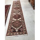A 20th century rug of Turkmen design having red, blue and cream ground, approx. 400 x 80cm