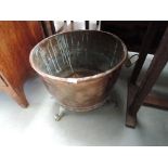 A 19th century copper log basket of cauldron form having later brass aplique lions mask handles