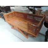 A late 20th Century hardwood Oriental window seat/settee having multispindle sides with solid