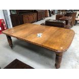 A late Victorian golden oak dining table on heavy turned legs with extra leaf, closed width approx