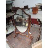 An early 20th Century mahogany toilet mirror of shield shape, width approx. 37cm