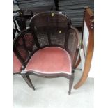 A late Victorian mahogany tub frame armchair having bergere cane panel and later pink upholstery
