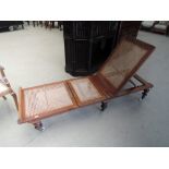 A 19th century mahogany day bed having later bergere cane panels and turned legs, worn label ,