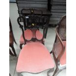A pair of late Victorian mahogany salon chairs having scroll and slat backs with later pink