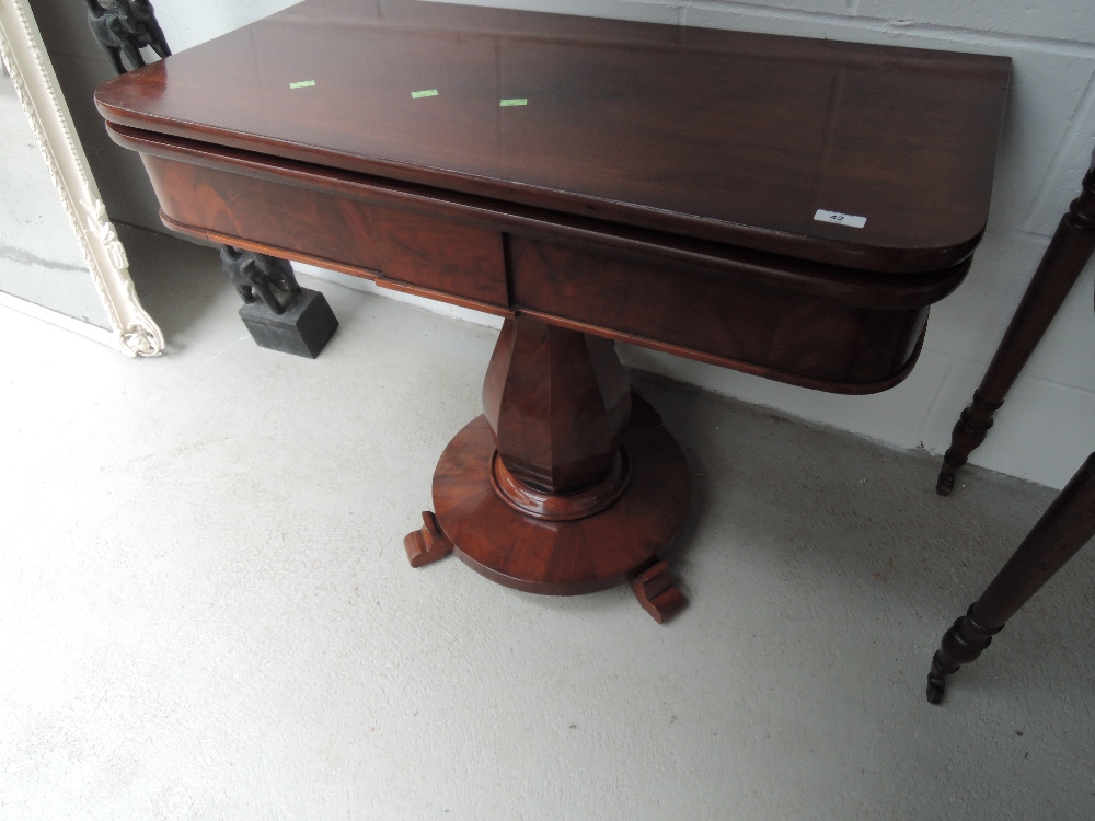 An early Victorian mahogany tea table having swivel top on cocia nut pedestal and circular