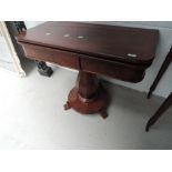 An early Victorian mahogany tea table having swivel top on cocia nut pedestal and circular