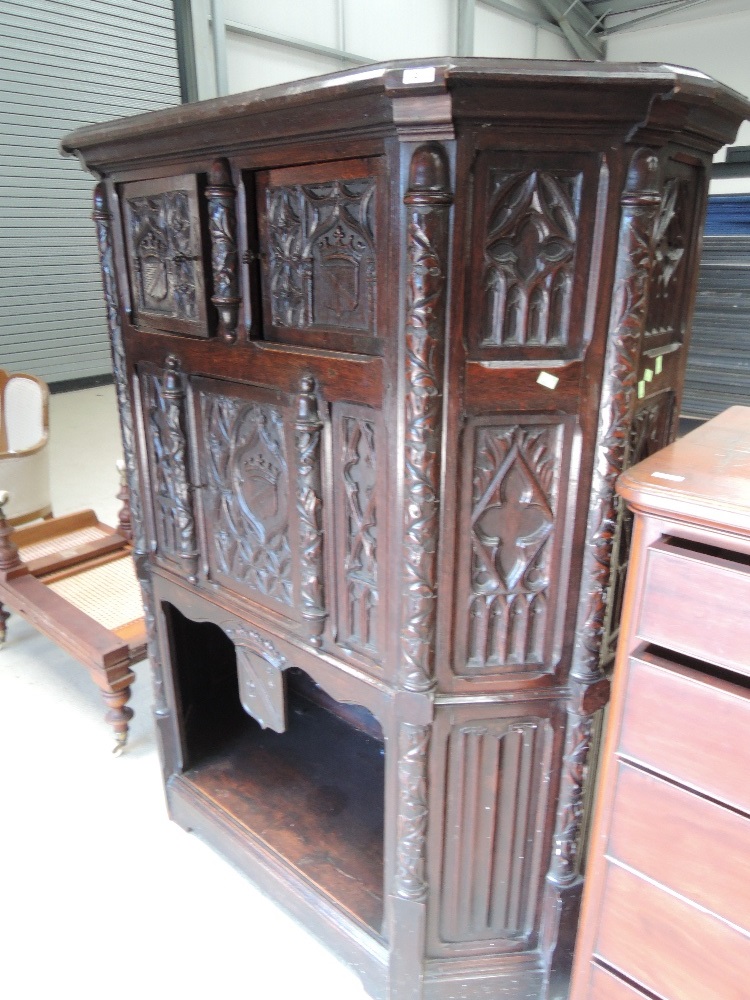 A late 19th century oak credence cupboard having extensive medieval style carved decoration with