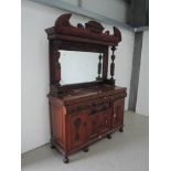 A late Victorian mahogany full height sideboard having crest and pillar support, mirror back over