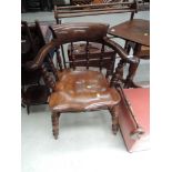 A late 19th/early 20th Century beech and elm captains chair having bobbin spindle back with scroll