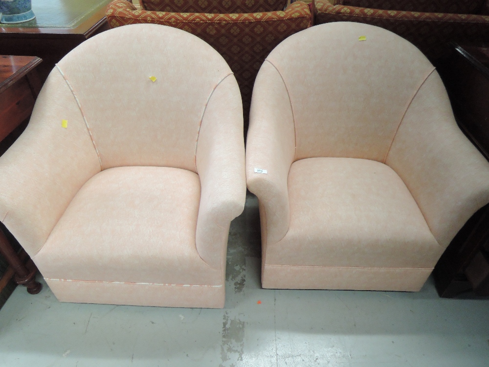 Two modern tub chairs having pink upholstery