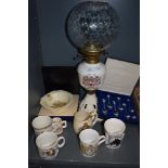An assortment of royal family commemorative items including oil lamp, bowls an mugs and spoons.