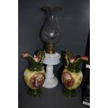 Two ceramic mantel urns and an oil lamp having fluted glass chimney.