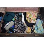A vintage suitcase containing a selection of ladies modern and retro skirts and similar. good