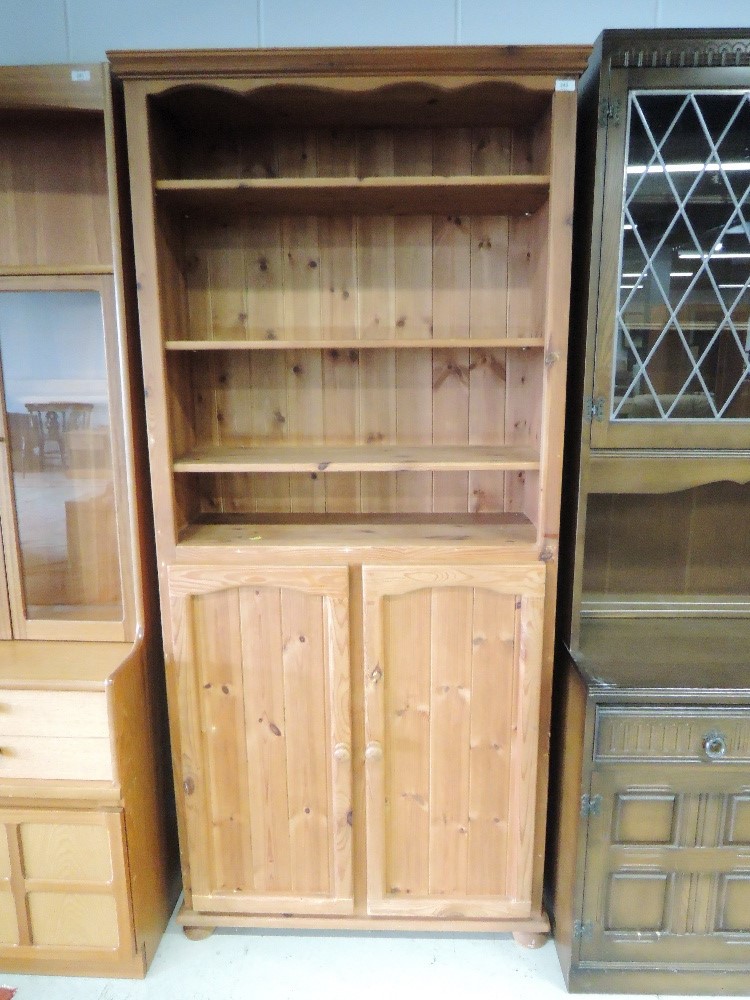 A modern pine shelf unit with cupboard under, approx. dimensions W85cm H193cm