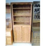 A modern pine shelf unit with cupboard under, approx. dimensions W85cm H193cm