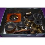 A box of various brass lenses