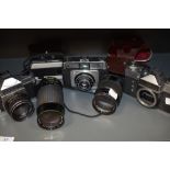 Three 35mm cameras and two lenses. An Ilford Sportsman, a Zenit E, a Chinon CS, a Prinzflex 135mm