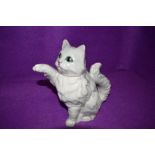 A quirky Beswick tea pot in the form of a white cat, the tail being the handle and the paw, its