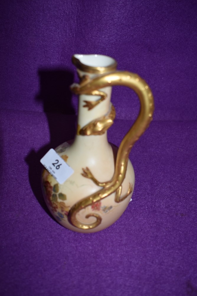 A Royal Worcester Blush Ivory ewer with gilt mythical beast moulded handle , The body being