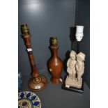Three vintage table lamps, two in wood one of which is carved and the other having a pair of