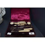 An early 20th century manicure set in plum coloured velvet and silk lined case.