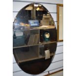 A vintage wooden backed large oval bevelled edge mirror.