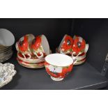 A cheerful collection of cups and saucers and side plates having bright red poppy pattern,