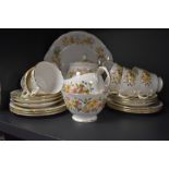 A part tea set having floral transfer design and gilt edging includes cake plate and tea pot,