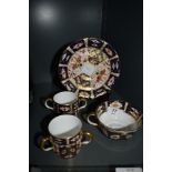 A Royal Crown Derby cup and saucer and two loving cups, one having two handles and the other