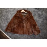 A short vintage brown fur jacket having two pockets to front and monogrammed lining.