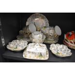 A vintage part tea set having gilt floral pattern, and garden scene depicting a crinoline lady