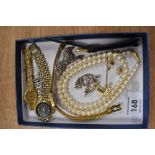 A small selection of costume jewellery including three wrist watches, string of simulated pearls,