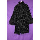 A Victorian/Edwardian black opera coat having flocked velvet floral pattern and fringed edging