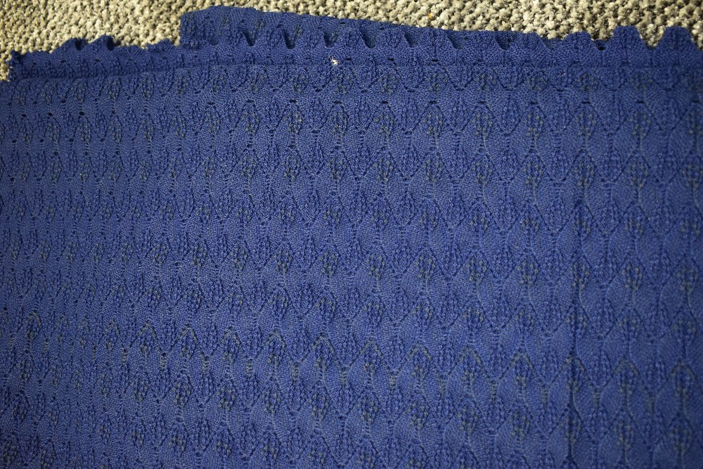 A finely knitted length of vintage navy blue wool having scalloped edges to the two finished