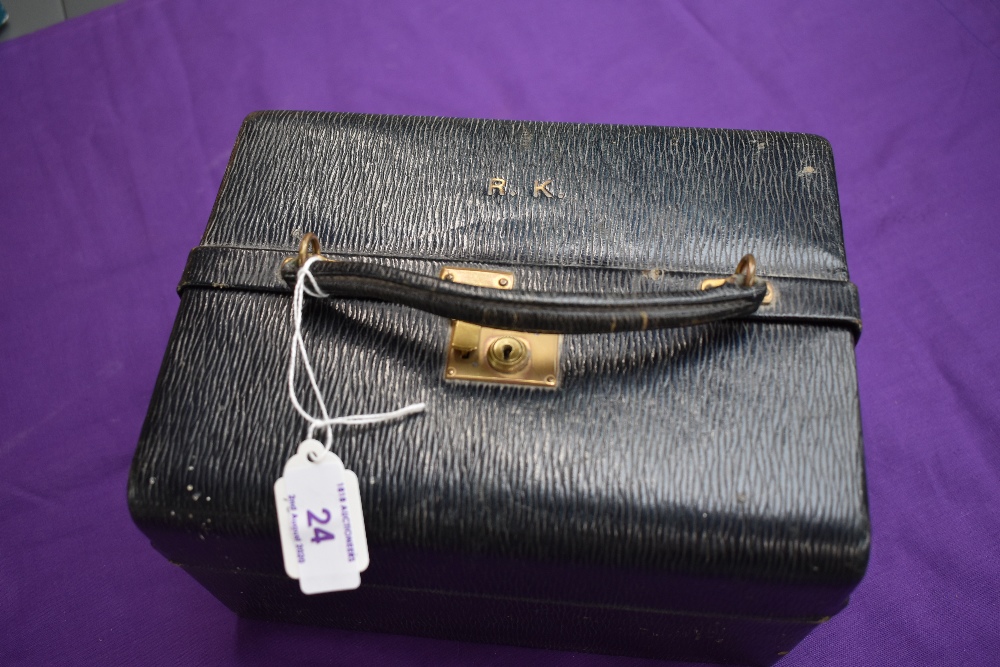 An antique Asprey and co vanity case containing glass bottles with hallmarked stoppers,a brush and